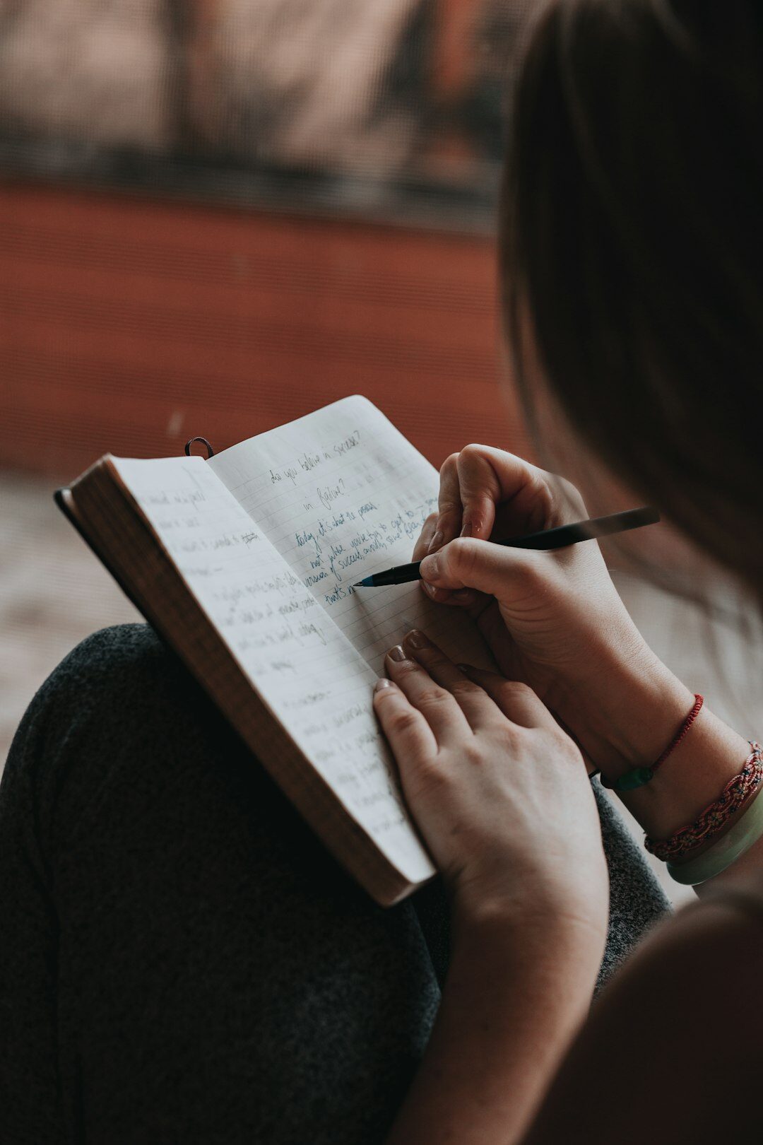 person writing in journal